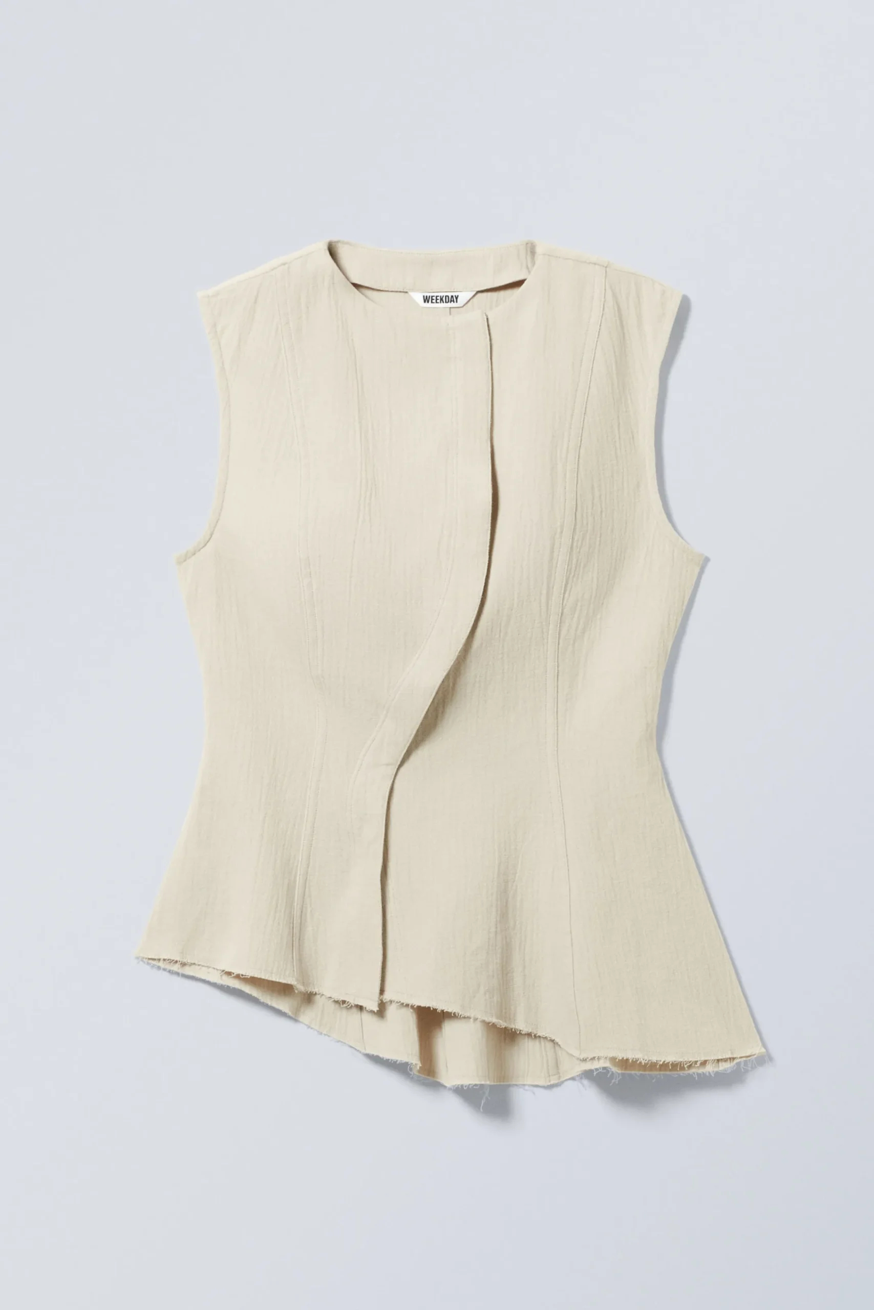 rmls_asymmetrisk_peplum_topp_3.webp Weekday Toppar<ÄRMLÖS ASYMMETRISK PEPLUM TOPP